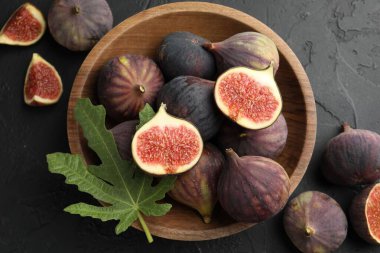 Taze incir kasede ve yeşil yaprak siyah desenli masada, düz yerde.