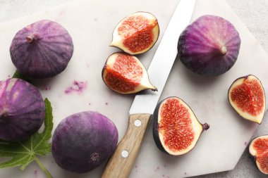 Taze incir, bıçak ve yeşil yaprak.