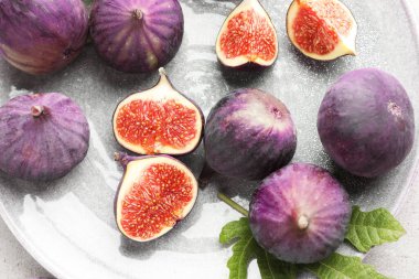 Taze incir ve yeşil yaprak masanın üstünde.