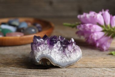 Farklı güzel değerli taşlar ve çiçekler ahşap masada, yakın plan