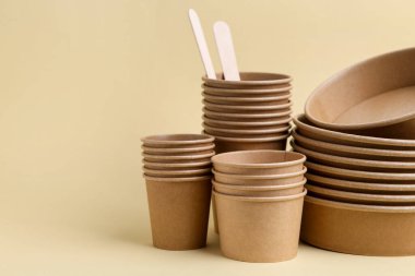 Bej arka planda tek kullanımlık sofra takımı, yakın plan. Metin için boşluk