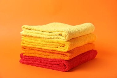 Turuncu arka planda bir yığın temiz havlu.