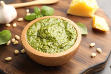 Tabakta taze pesto sosu ve masada malzemeler, yakın plan.