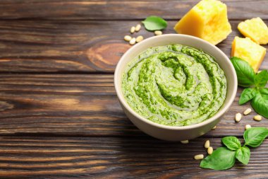 Tabakta taze pesto sosu ve ahşap masada malzemeler, yakın plan. Metin için boşluk