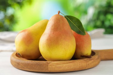 Taze olgun armutlar beyaz ahşap masa üzerinde, yakın plan.