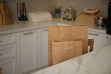 Mutfaktaki sandalyede kağıt torbalar, yakın plan. Metin için boşluk