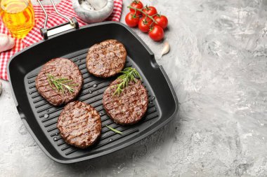 Izgara köfteli tava, domates ve baharatlar gri masada. Metin için boşluk