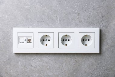 İçerideki gri duvarda elektrik prizleri var.