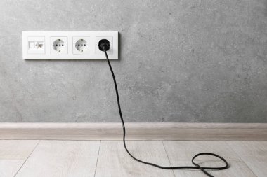 Gri duvarda prizdeki güç prizi, metin için boşluk