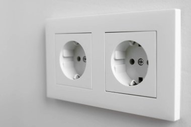 Beyaz duvarda elektrik prizleri, yakın plan.