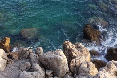 Sea with clean water and stones on shore in summer, above view