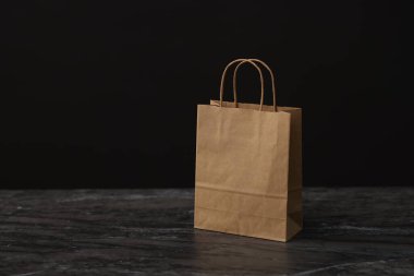 Masada siyah arka planda kağıt alışveriş torbası var. Metin için boşluk