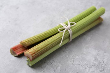 Gri masada taze ravent sapları, yakın plan.