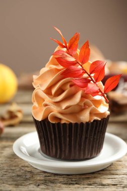 Gri arka planda, üzerinde kırmızı yapraklar olan lezzetli bir kek, yakın plan. Sonbahar atmosferi