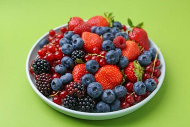 Yeşil arka planda farklı olgun meyveler, yakın plan