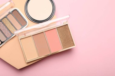 Renkli göz falı paletleri ve pembe arka planda pudra gösterimi, üst manzara. Metin için boşluk