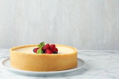Taze böğürtlenli nefis cheesecake ve beyaz mermer masa üzerinde nane, metin için yer