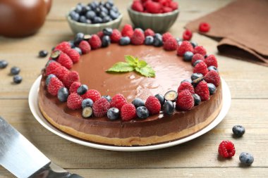 Lezzetli çikolatalı kek, böğürtlenli ve nane şekerli, ahşap masa, yakın plan.