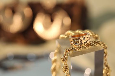 Bulanık arka planda güzel altın mücevherler, yakın plan. Metin için boşluk