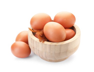 Tabakta çiğ tavuk yumurtası ve beyaz tüyler.