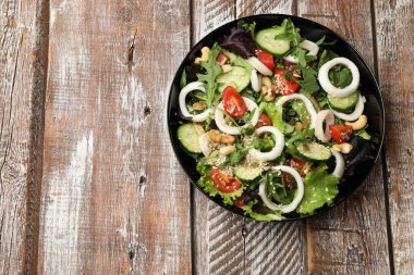 Ahtapot yüzüklü, sebzeli, ahşap masadaki fındıklı nefis salata. Metin için boşluk