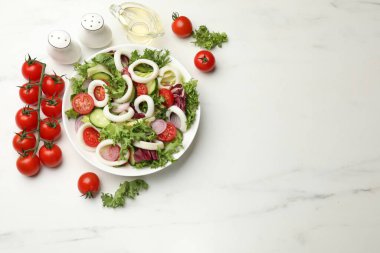 Beyaz mermer masada servis edilen mürekkep balığı halkalı ve sebzeli leziz salata. Metin için boşluk