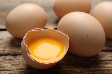 Ahşap masada tüm tavuk yumurtaları kırılmış, yakın plan.