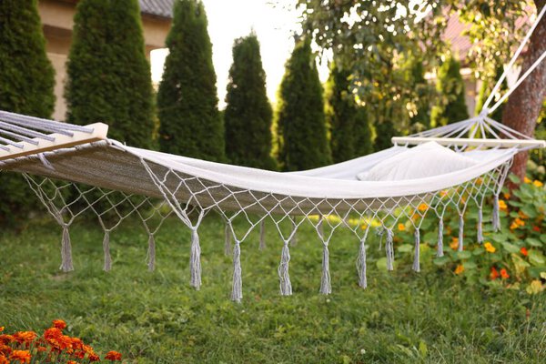 Comfortable white hammock with pillow in garden
