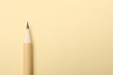 Bej arka planda keskin bir grafit kalem, üst manzara. Metin için boşluk