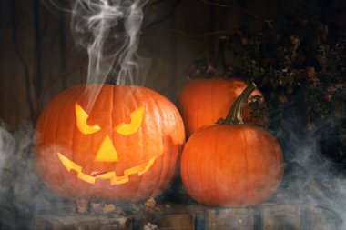Cadılar Bayramı kutlaması. Ürkütücü Jack-o-Lantern, balkabağı ve duman
