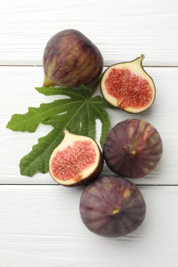 Taze incir ve yeşil yaprak beyaz ahşap masa üzerinde, düz yatıyordu.