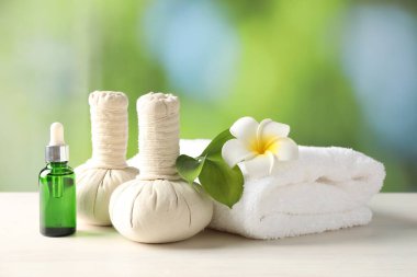 Güzel bir spa kompozisyonu, beyaz ahşap masa üzerinde bitkisel torbalar, bulanık arka plan, yakın çekim.