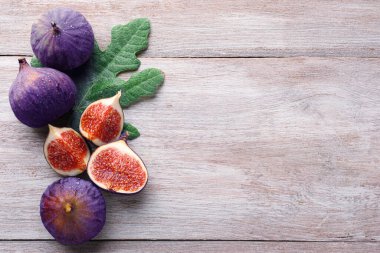 Taze incir ve ahşap masada yeşil yaprak. Metin için boşluk