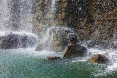 Güzel bir dağ şelalesi ve kayaların manzarası.