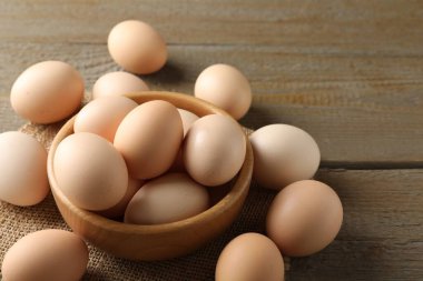 Tahta masadaki kasede çiğ tavuk yumurtası, yakın plan. Metin için boşluk