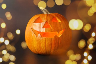 Cadılar Bayramı balkabağı feneri. Kabak, oyulmuş tüyler ürpertici bir yüz, bokeh etkisi