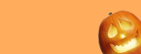 Halloween poster design with peeking jack-o-lantern against pale orange background. Space for text