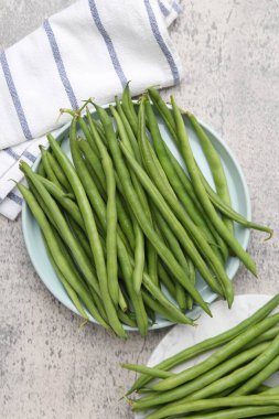 Gri desenli masa üzerinde taze yeşil fasulye kabukları.