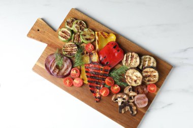 Vejetaryen barbeküsü. Beyaz mermer masada leziz ızgara sebzeler, üst manzara.