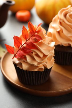 Gri masa üzerinde kırmızı yaprakları olan lezzetli kekler, yakın plan. Sonbahar atmosferi