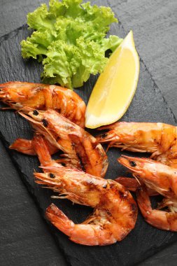 Siyah masada limonlu ve marullu ızgara karides. Lezzetli deniz ürünleri yemeği.