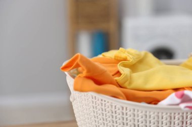 Çamaşır sepetinin içinde temiz bebek kıyafetleri var, yakın plan. Metin için boşluk