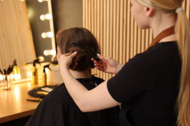 Kuaför müşteriyle kuaförde çalışıyor, yakın plan.