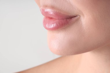 Açık gri arka planda güzel dudaklı bir kadın, makro manzaralı. Metin için boşluk