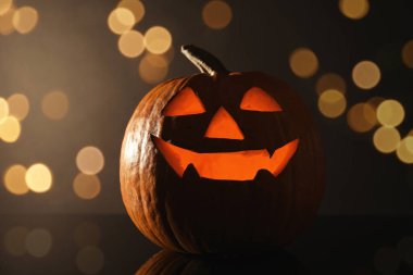 Cadılar Bayramı balkabağı feneri. Kabak, oyulmuş tüyler ürpertici bir yüz, bokeh etkisi