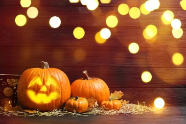 Cadılar Bayramı balkabağı feneri. Kabak, oyulmuş tüyler ürpertici bir yüz, bokeh etkisi