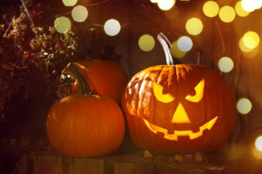 Cadılar Bayramı balkabağı feneri. Kabak, oyulmuş tüyler ürpertici bir yüz, bokeh etkisi