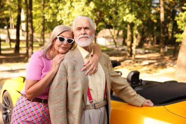 Modern Cabriolet yakınlarında şık bir yaşlı çift.