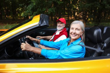 Üst düzey bir çift açık havada eğleniyor, seçici bir odak noktası var.