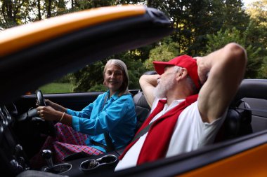 Üst düzey bir çift açık havada eğleniyor, seçici bir odak noktası var.